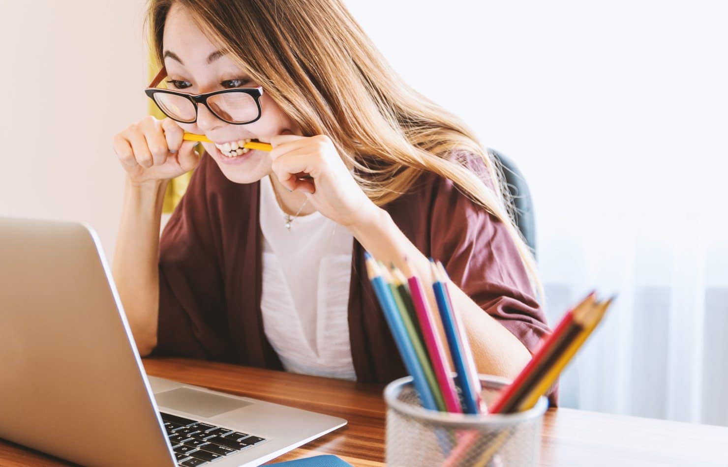 School biting pencil doing school work.